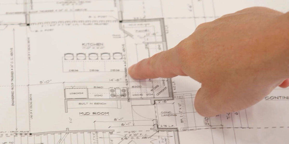 blueprints with a hand pointing