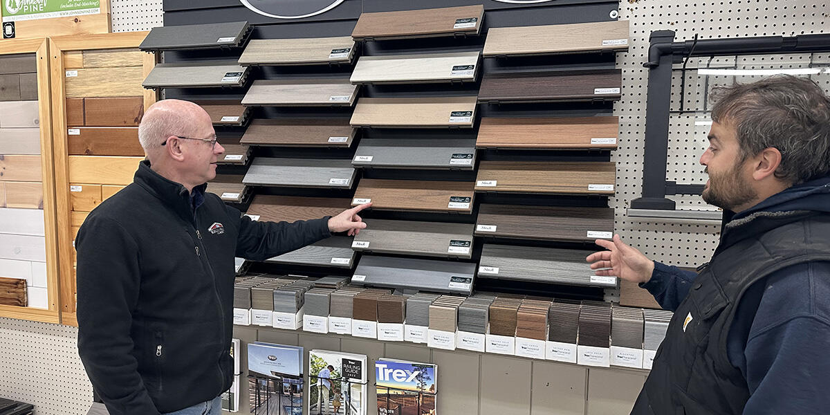 Team member and customer looking at hardwood flooring